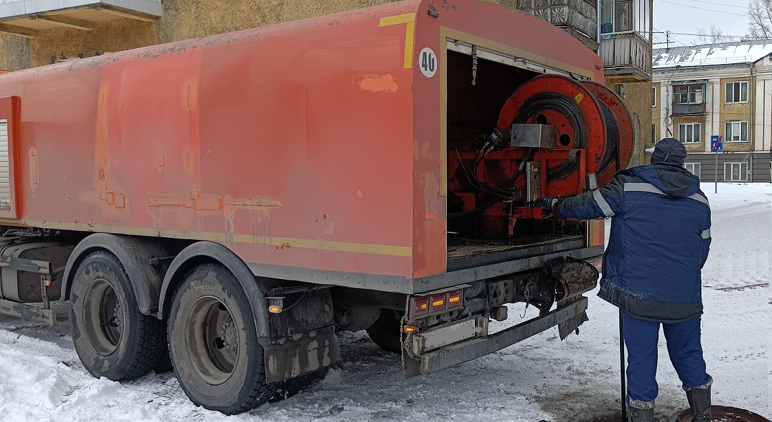 Каналопромывочная машина и работник прочищают засор в канализационной системе в Гремячинске